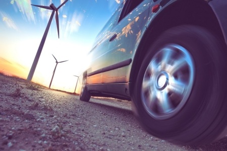EV car next to wind turbines